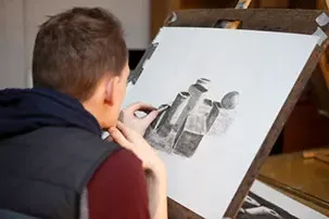 Student creating a charcoal drawing
